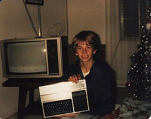 A photo of young Paul holding a TI-99/4A computer